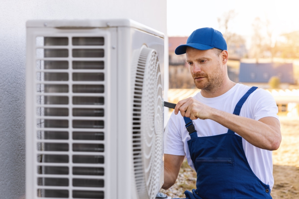 HVAC technician servicing an outdoor air conditioning unit